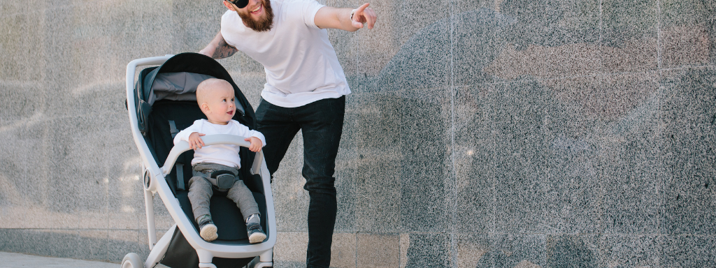 introduce art to baby ideas - the photo shows a man with a baby in a pushchair pointing at something in a modern-looking building
